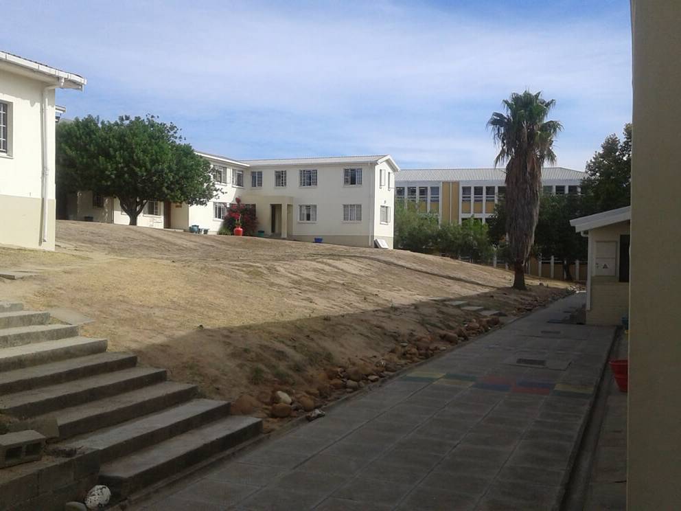 View of a school campus featuring several buildings and a pathway with steps.
